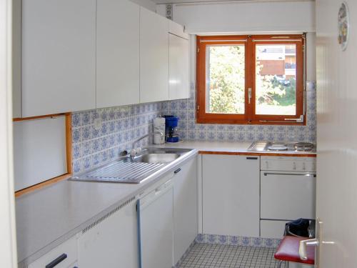 ナンダにあるApartment Panoramic G4 by Interhomeの白いキャビネット、シンク、窓付きのキッチン