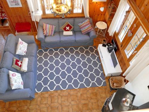 una vista aérea de una sala de estar con un sofá azul en Chalet Les Muguets by Interhome en Nendaz