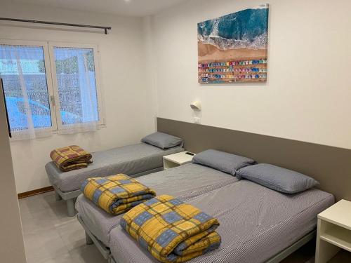 a room with three beds and a painting on the wall at NEW Apartment Diana Ovest in Bibione