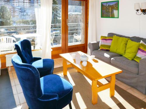 un soggiorno con divano, tavolo e sedie di Apartment Muverans I B1 by Interhome a Nendaz