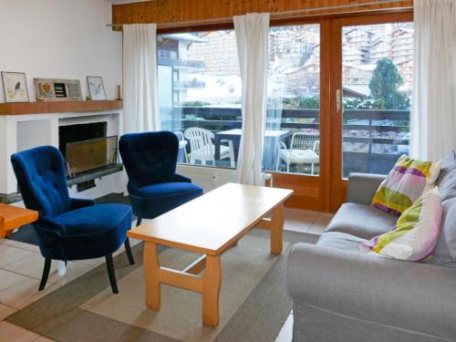 un soggiorno con divano, sedie e tavolo di Apartment Muverans I B1 by Interhome a Nendaz