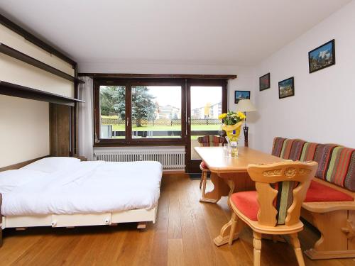 1 dormitorio con cama, escritorio y mesa en Apartment Residence A-1 by Interhome, en Zermatt