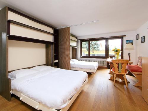 1 dormitorio con 1 cama blanca grande y escritorio en Apartment Residence A-1 by Interhome, en Zermatt