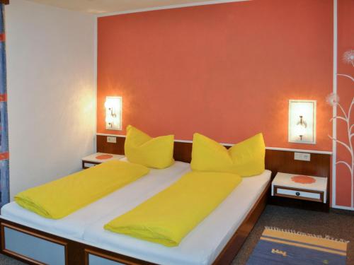 1 dormitorio con 2 camas con almohadas amarillas en Apartment Miramonte - KPL280 by Interhome, en Kappl