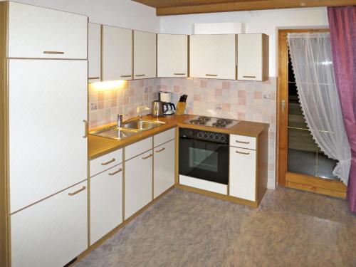 カップルにあるApartment Romantika - KPL351 by Interhomeの白いキャビネット、シンク、冷蔵庫付きのキッチンが備わります。
