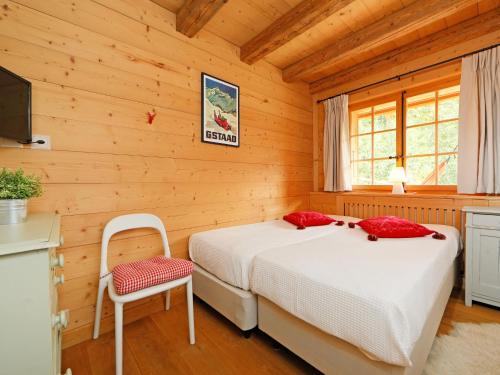 a bedroom with a bed and a chair in a room at Chalet Saint Piran-1 by Interhome in Villars-sur-Ollon