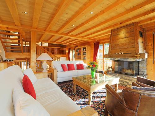 a living room with a white couch and a fireplace at Chalet Khamariah by Interhome in Villars-sur-Ollon