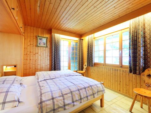 a bedroom with a bed in a room with windows at Chalet Dejo A Dzeu by Interhome in Nendaz