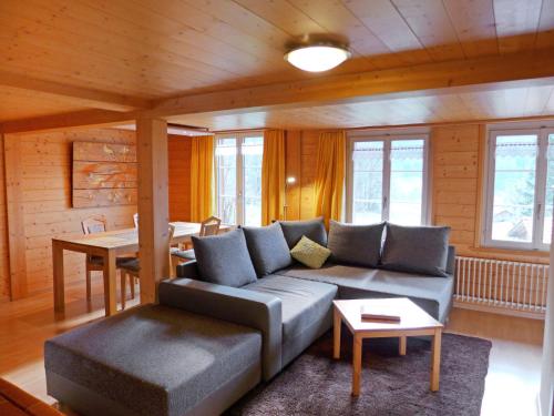 ein Wohnzimmer mit einem Sofa und einem Tisch in der Unterkunft Chalet Hüsli by Interhome in Brienzwiler