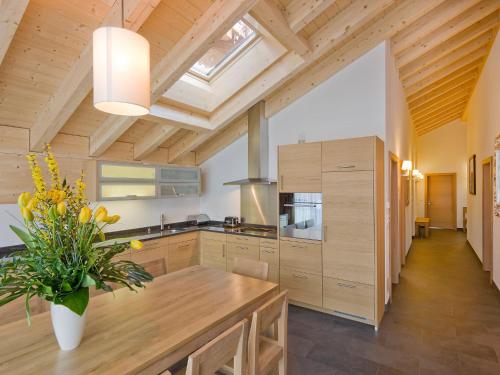 una cocina con armarios de madera y un jarrón de flores en Apartment Zur Matte B-11 by Interhome en Zermatt