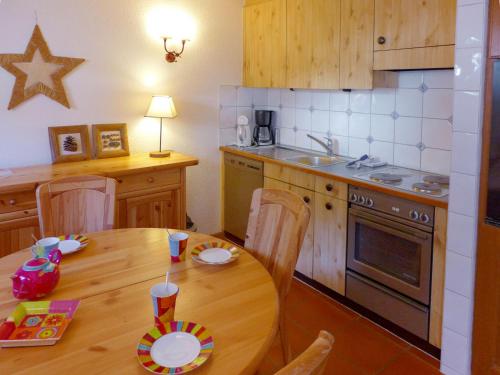 a kitchen with a wooden table and a kitchen with a stove at Apartment Résidence Christina Apt- 305 by Interhome in Crans-Montana