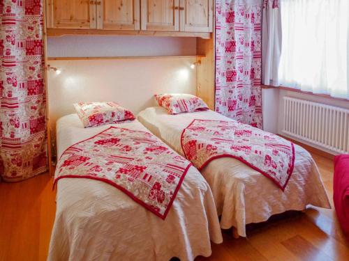 a bedroom with two beds with red and white blankets at Apartment Christina 305 by Interhome in Crans-Montana