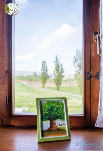 a picture of a tree in front of a window at Antiche Vie B&B in Serramazzoni