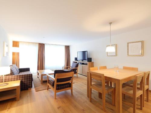 Apartment Zur Matte B-7 by Interhome في زيرمات: غرفة معيشة مع طاولة وغرفة طعام