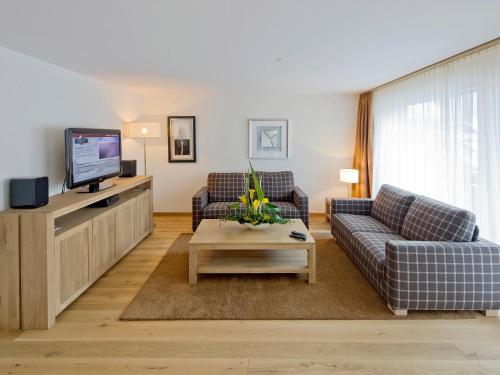 a living room with two couches and a tv at Apartment Zur Matte B-8 by Interhome in Zermatt
