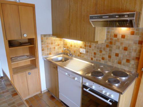 a kitchen with a sink and a stove top oven at Apartment Arsets 203-12 by Interhome in Arveyes
