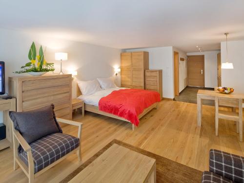 1 dormitorio con 1 cama con manta roja en Apartment Zur Matte B-5 by Interhome, en Zermatt