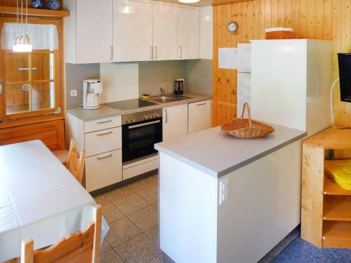 a kitchen with white cabinets and a counter top at Chalet Allegra by Interhome in Grächen