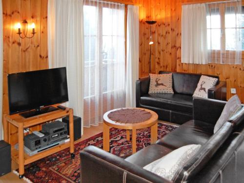 Il comprend un salon doté d'un canapé et d'une télévision à écran plat. dans l'établissement Chalet Magicien by Interhome, à Nendaz