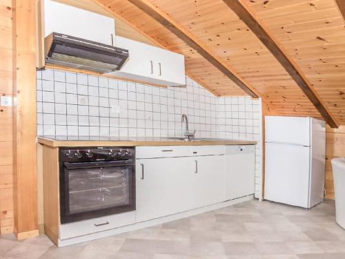 una cucina con elettrodomestici bianchi e soffitto in legno di Apartment Kelly by Interhome a Grächen