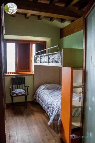 a bedroom with two bunk beds and a chair at Antiche Vie B&B in Serramazzoni