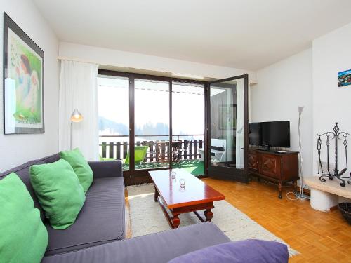 ein Wohnzimmer mit einem Sofa und einem TV in der Unterkunft Apartment Marignac 33 by Interhome in Villars-sur-Ollon