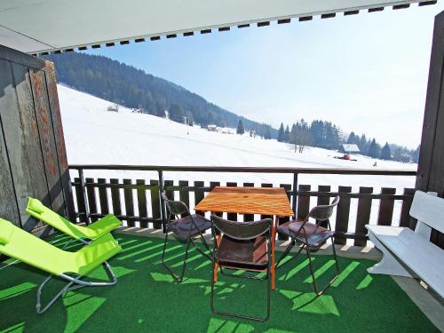 ヴィラール・シュル・オロンにあるApartment Marignac 33 by Interhomeの雪の景色を望むバルコニー(テーブル、椅子付)
