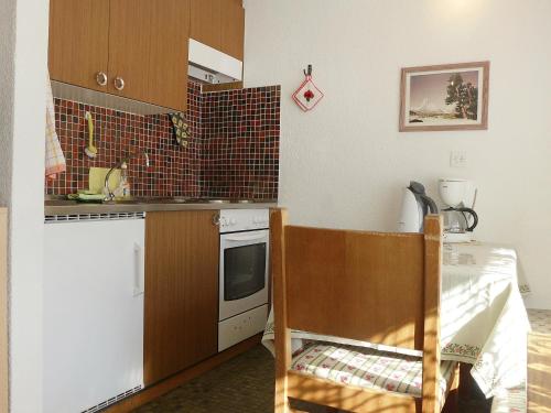 eine kleine Küche mit einem Herd und einem Tisch in der Unterkunft Apartment Castor und Pollux-1 by Interhome in Täsch