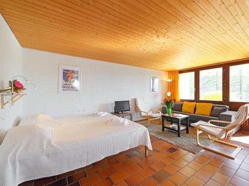 Un dormitorio con una cama y una sala de estar. en Apartment Les Beluardes Bl- 151-2 by Interhome, en Taveyannaz