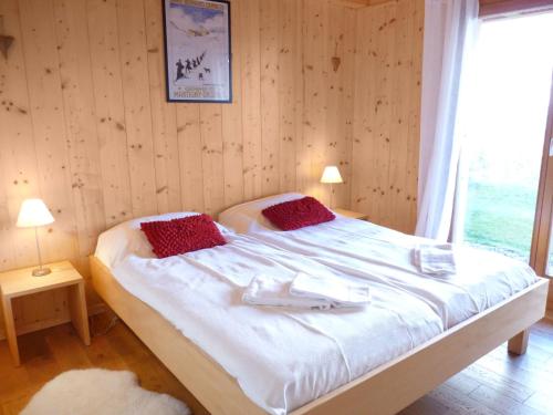 a bedroom with a large white bed with a window at Chalet Chloé by Interhome in Ovronnaz