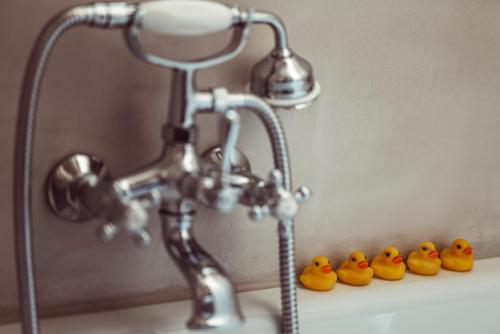 a group of rubber ducks sitting next to a bathroom faucet at Hôtel Monsieur Aristide in Paris