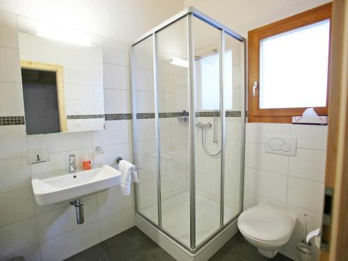 a bathroom with a shower and a sink and a toilet at Chalet Chloé by Interhome in Ovronnaz