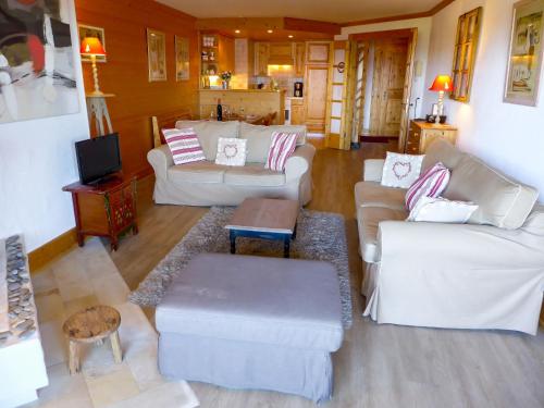 een woonkamer met witte banken en een tv bij Apartment Résidence Le Bristol 14 by Interhome in Villars-sur-Ollon