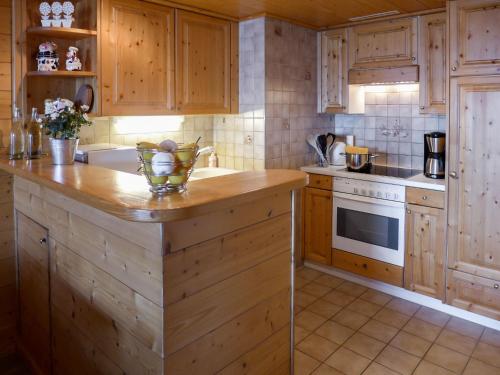 ヴィラール・シュル・オロンにあるApartment Résidence Le Bristol 14 by Interhomeのキッチン(木製キャビネット、カウンタートップ付)