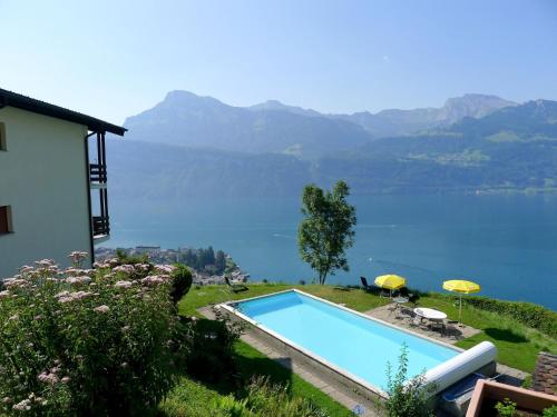 a swimming pool with a view of a body of water at Apartment Platten by Interhome in Gersau