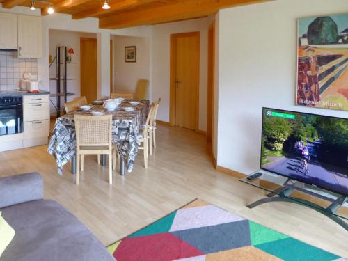uma cozinha e sala de jantar com uma mesa e uma televisão em Apartment Sundance 10 by Interhome em Les Crosets