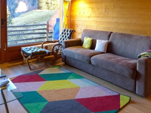uma sala de estar com um sofá e um tapete colorido em Apartment Sundance 10 by Interhome em Les Crosets