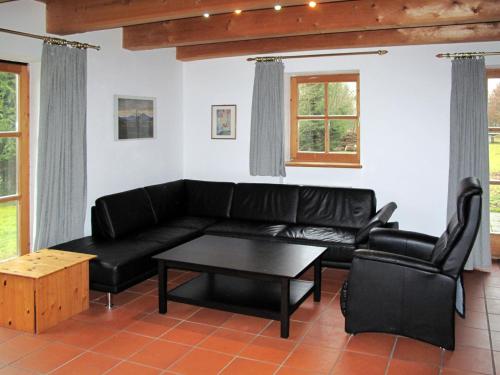 a living room with a black couch and a table at Holiday Home Ilztal by Interhome in Allmunzen