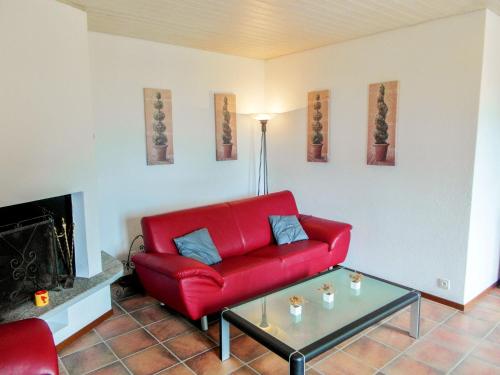 ロカルノにあるApartment Appartamento Tazzino by Interhomeのリビングルーム(赤いソファ、コーヒーテーブル付)