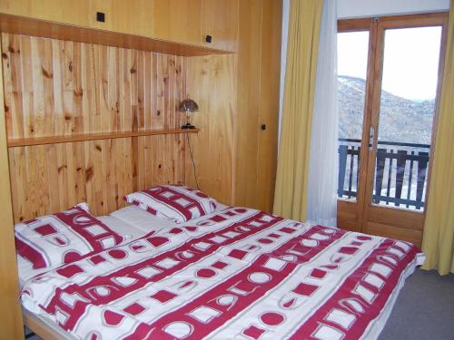 1 dormitorio con 1 cama con sábanas rojas y blancas en Apartment Beausoleil H by Interhome, en Veysonnaz