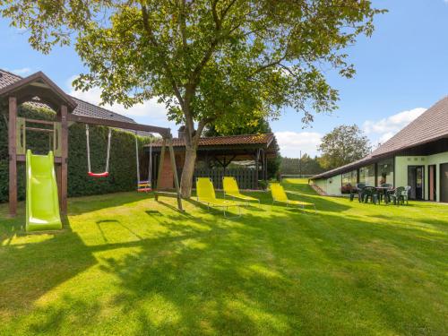a yard with a playground with yellow chairs and a tree at Holiday Home Haus Polivka by Interhome in Třebíšov