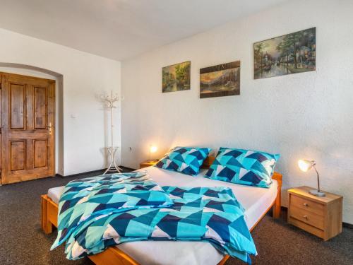 a bedroom with a bed with a blue and white comforter at Holiday Home Haus Polivka by Interhome in Třebíšov