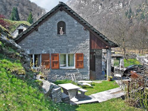 a small stone house with a dog in the window at Holiday Home La Rustica by Interhome in Brione