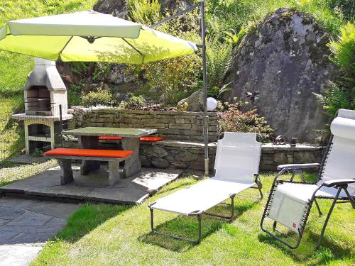 un patio con mesa, sillas y sombrilla en Holiday Home Casa la Rustica by Interhome, en Brione
