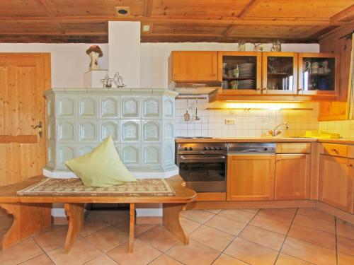eine Küche mit Holzschränken und einem Tisch darin in der Unterkunft Chalet Auhäusl by Interhome in Fügenberg