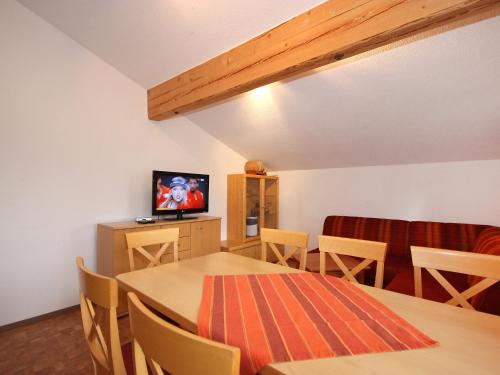 a room with a table and chairs and a television at Apartment Gasteighof-1 by Interhome in Kapfing