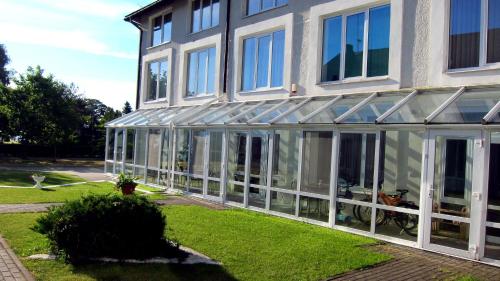 a large glass house with a lot of windows at Prie Ąžuolo in Juodkrantė