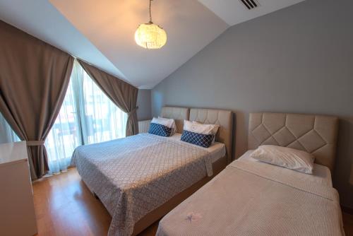a bedroom with two beds and a window at CTS Elysium Residence Taksim in Istanbul