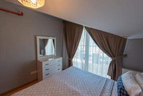 a bedroom with a bed and a mirror and a window at CTS Elysium Residence Taksim in Istanbul