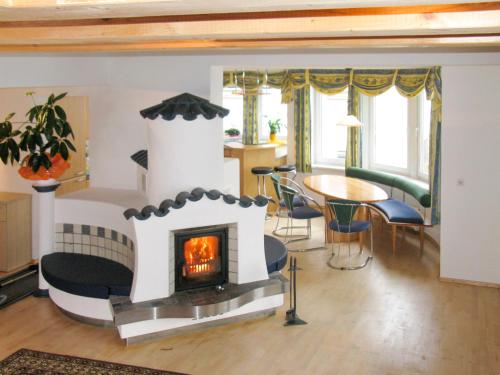 - un salon avec une cheminée et une table dans l'établissement Apartment Schmiedbach - STA255 by Interhome, à Sankt Anton am Arlberg